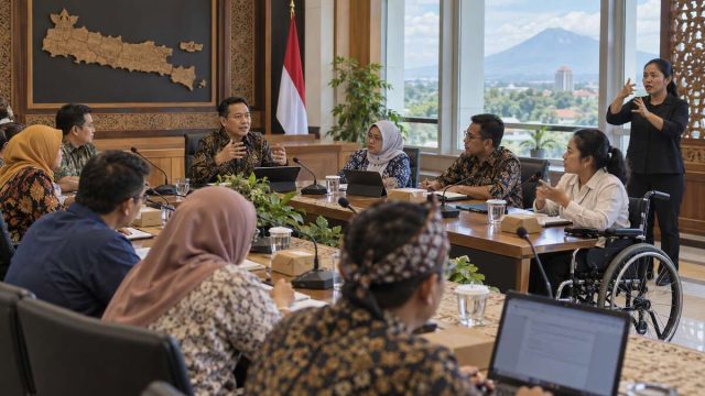 Pengguna kursi roda dan peserta rapat berdiskusi di ruang kebijakan publik yang aksesibel