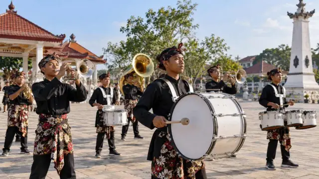 Sejumlah pemain drumband berlatih di lapangan terbuka pada pagi hari.