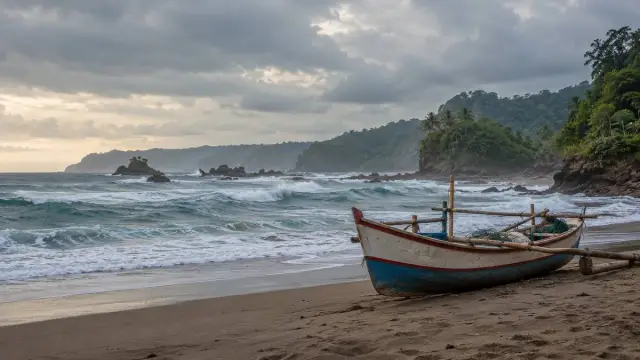Ombak di pesisir dan perahu ditambatkan di daratan tanpa orang.